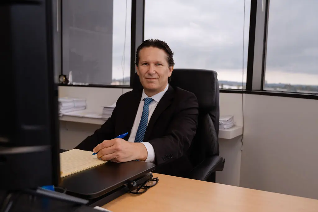 Picture of Kevin Singer: Court Receiver Phoenix sitting at his office desk